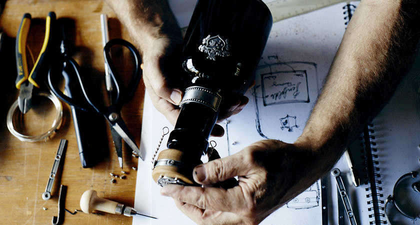 Overhead of 50 year old rare tawny bottle being assembled. Sketches appear under the bottle